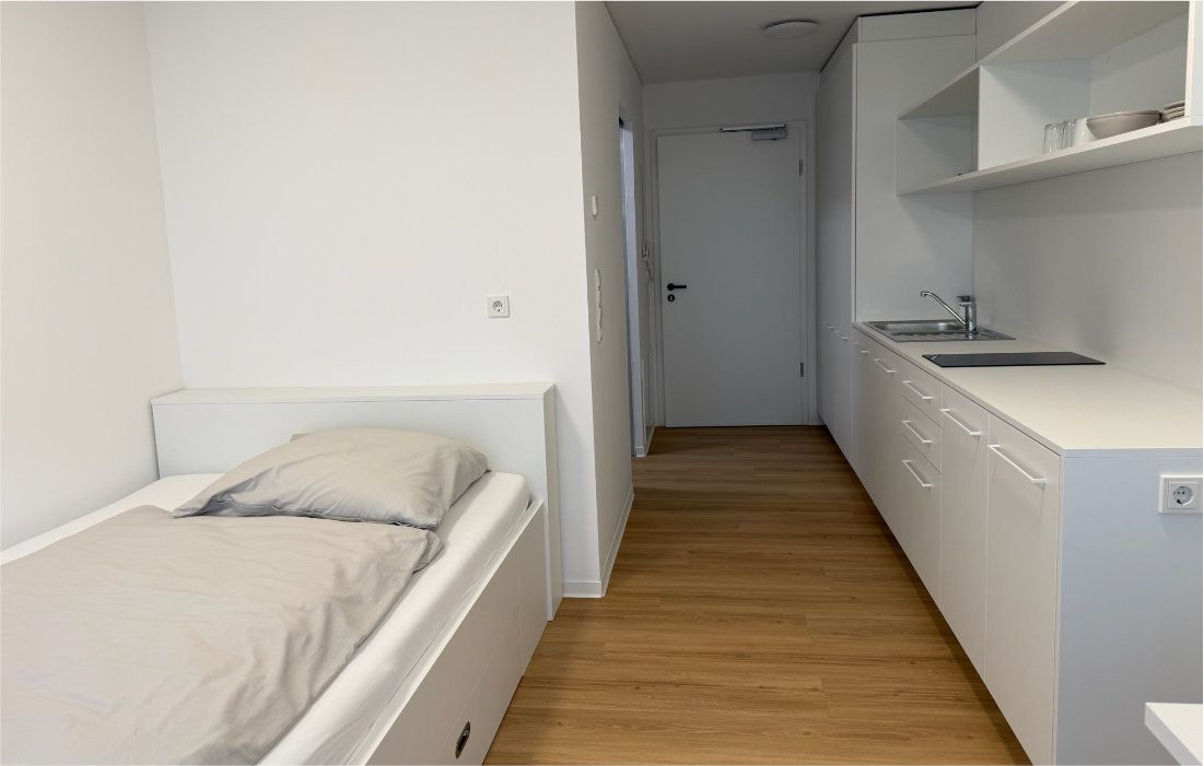 Single-Apartment mit Bett, Küchenzeile und Flur